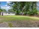 Large, fenced backyard with a lush lawn, mature trees, and a patio area, perfect for outdoor activities at 1218 E Woodlawn Rd, Charlotte, NC 28209