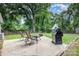 Backyard patio with outdoor seating, grill, and view of the well-maintained lawn and mature trees at 1218 E Woodlawn Rd, Charlotte, NC 28209