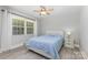 Serene bedroom featuring light blue bedding, a ceiling fan, and natural light at 1218 E Woodlawn Rd, Charlotte, NC 28209