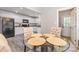 Bright dining area featuring a glass table, neutral-toned chairs, and a view into the kitchen at 1218 E Woodlawn Rd, Charlotte, NC 28209