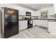 Well-lit kitchen with black appliances, white cabinets, and durable countertops at 1218 E Woodlawn Rd, Charlotte, NC 28209