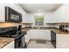 Spacious kitchen featuring matching black appliances and wood-look laminate flooring at 1218 E Woodlawn Rd, Charlotte, NC 28209