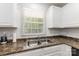 Bright kitchen area featuring a stainless steel sink and window with a view of the yard at 1218 E Woodlawn Rd, Charlotte, NC 28209
