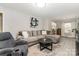 Spacious living room with wood-look floors, large sectional couch, recliner, and bright natural light at 1218 E Woodlawn Rd, Charlotte, NC 28209
