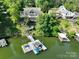 Aerial view of stunning lakefront property with a private dock, wooden stairway to the water, and lush greenery at 126 Strand Rd, New London, NC 28127