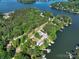 Aerial view showcasing neighborhood nestled among trees with waterfront homes featuring docks and scenic lake access at 126 Strand Rd, New London, NC 28127