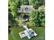 Lakefront home with private dock, multiple boats, and lush greenery surrounding the property at 126 Strand Rd, New London, NC 28127