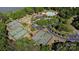 Aerial view showcasing the community's tennis courts, pool, and amenities against a backdrop of lush greenery and lake at 12835 Ninebark Trl, Charlotte, NC 28278