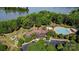 Aerial view highlighting the community clubhouse and pool amenities nestled beside a serene lake and lush greenery at 12835 Ninebark Trl, Charlotte, NC 28278
