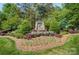 Stone community entrance sign, surrounded by lush landscaping, sets an elegant and welcoming tone at 12835 Ninebark Trl, Charlotte, NC 28278