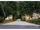 Private tree-lined driveway leading to a stately home with stone gateposts and elegant lighting at 12835 Ninebark Trl, Charlotte, NC 28278
