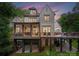 Back of a two-story house with a large deck, outdoor dining, and covered porch at 12835 Ninebark Trl, Charlotte, NC 28278