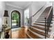 Inviting foyer with hardwood floors, staircase, and an elegant arched doorway leading to the outside at 12835 Ninebark Trl, Charlotte, NC 28278