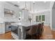 Modern white kitchen featuring a large island with seating and stainless steel appliances at 12835 Ninebark Trl, Charlotte, NC 28278