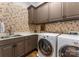 Functional laundry room with a sink, countertop space, ample cabinetry, and modern washer/dryer units at 12835 Ninebark Trl, Charlotte, NC 28278