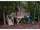 Backyard playhouse featuring a slide, porch, stairs, and swing at 12835 Ninebark Trl, Charlotte, NC 28278