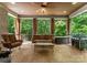 Covered porch with comfortable seating, an outdoor grill, and a ceiling fan for relaxed outdoor living at 12835 Ninebark Trl, Charlotte, NC 28278