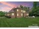 Beautiful backyard with well-manicured lawn, brick house and outdoor seating at 1400 Delaney Dr, Matthews, NC 28104