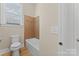 Bathroom with a tiled shower, tub, and a commode at 1400 Delaney Dr, Matthews, NC 28104