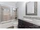 Bathroom featuring a tiled shower and granite counters with a framed mirror at 1400 Delaney Dr, Matthews, NC 28104