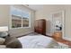 A bedroom features a wooden wardrobe, and access to another room with hardwood floors and neutral paint at 1400 Delaney Dr, Matthews, NC 28104