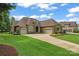 Beautiful brick home featuring a three-car garage, manicured lawn and lush landscaping at 1400 Delaney Dr, Matthews, NC 28104