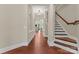 Spacious hallway with hardwood floors, white trim, arched doorways, and staircase to the upper level at 1400 Delaney Dr, Matthews, NC 28104