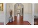 Inviting hallway with hardwood floors, arched doorway, staircase, and decorative accents at 1400 Delaney Dr, Matthews, NC 28104