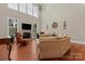 Bright living room with soaring ceilings, large windows, fireplace and hardwood floors for welcoming ambiance at 1400 Delaney Dr, Matthews, NC 28104
