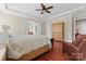 Spacious bedroom with wood floors, tray ceiling, and a doorway to the ensuite bathroom at 1400 Delaney Dr, Matthews, NC 28104