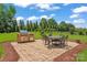 Outdoor patio with brick pavers, a built-in grill, and a dining table with chairs in the lush backyard at 1400 Delaney Dr, Matthews, NC 28104