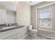 Bright bathroom featuring a large vanity with a granite countertop, toilet, and window at 14010 Pinyon Pine Ln, Charlotte, NC 28215