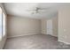 The room features a neutral interior, carpet, ceiling fan, and doorways at 14010 Pinyon Pine Ln, Charlotte, NC 28215