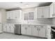 Modern kitchen featuring white cabinets, stainless steel dishwasher, and sleek countertops, offering a functional design at 14010 Pinyon Pine Ln, Charlotte, NC 28215