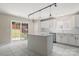 Bright kitchen with an island, white cabinets, marble tile flooring, and a sliding glass door to the backyard at 14010 Pinyon Pine Ln, Charlotte, NC 28215