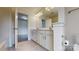 Bathroom boasts a white vanity with double sinks, modern lighting, and tiled floor with an open doorway at 14506 Knowledge Cir, Charlotte, NC 28277