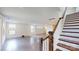Bright living room features hardwood floors, white walls, and stairs with dark wood handrail at 14506 Knowledge Cir, Charlotte, NC 28277
