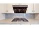 The stovetop is surrounded by gray subway tile and plenty of white cabinets at 14506 Knowledge Cir, Charlotte, NC 28277