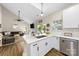 Bright open concept kitchen features stainless appliances, white cabinets, and breakfast bar overlooking the living room at 146 Comata Rd, Mooresville, NC 28117