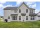 Two-story home featuring a well-manicured backyard with a lush green lawn and black grill at 15037 Taylor Ridge Ln # 25, Charlotte, NC 28273