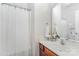 Clean bathroom featuring wood vanity, large mirror, and tub with white shower curtain at 15037 Taylor Ridge Ln # 25, Charlotte, NC 28273