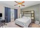 Modern bedroom with ceiling fan, shelves, and bright window complemented by blue accent wall at 15037 Taylor Ridge Ln # 25, Charlotte, NC 28273