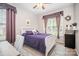 Charming bedroom featuring white bed frame, ceiling fan, and elegant purple accents and window curtains at 15037 Taylor Ridge Ln # 25, Charlotte, NC 28273