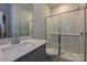 Modern bathroom with a white vanity, quartz countertop, and walk-in shower with glass doors at 1505 Harper Landing Blvd, Stanley, NC 28164