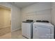 Bright laundry room includes new washer and dryer, and wire shelving for storage at 1505 Harper Landing Blvd, Stanley, NC 28164