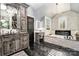 Luxurious bathroom featuring a soaking tub, elegant vanity, and stone accent wall at 16109 Reynolds Dr, Indian Land, SC 29707