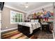 The bedroom features a unique superhero mural, dark wood floors, and plenty of natural light at 16109 Reynolds Dr, Indian Land, SC 29707