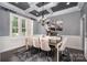 Elegant dining room with modern chandelier, wainscoting, and large windows with shutters at 16109 Reynolds Dr, Indian Land, SC 29707