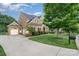 Side exterior view of home with a three-car garage and lush green lawn at 16109 Reynolds Dr, Indian Land, SC 29707