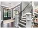 Elegant foyer with dark hardwood floors, staircase and a view into the adjacent room at 16109 Reynolds Dr, Indian Land, SC 29707